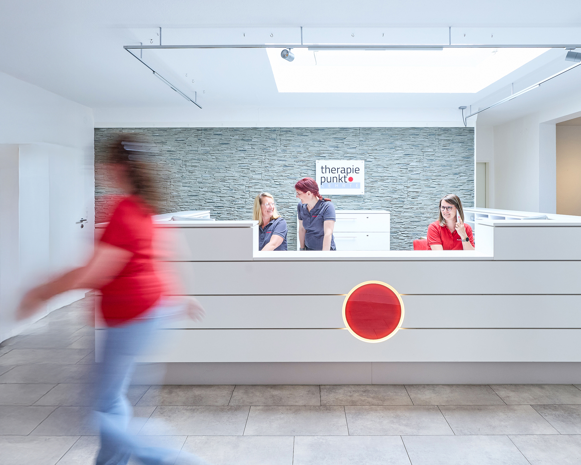Empfangstresen der Praxis Therapiepunkt in Lehrte, drei Personen hinter dem Tresen